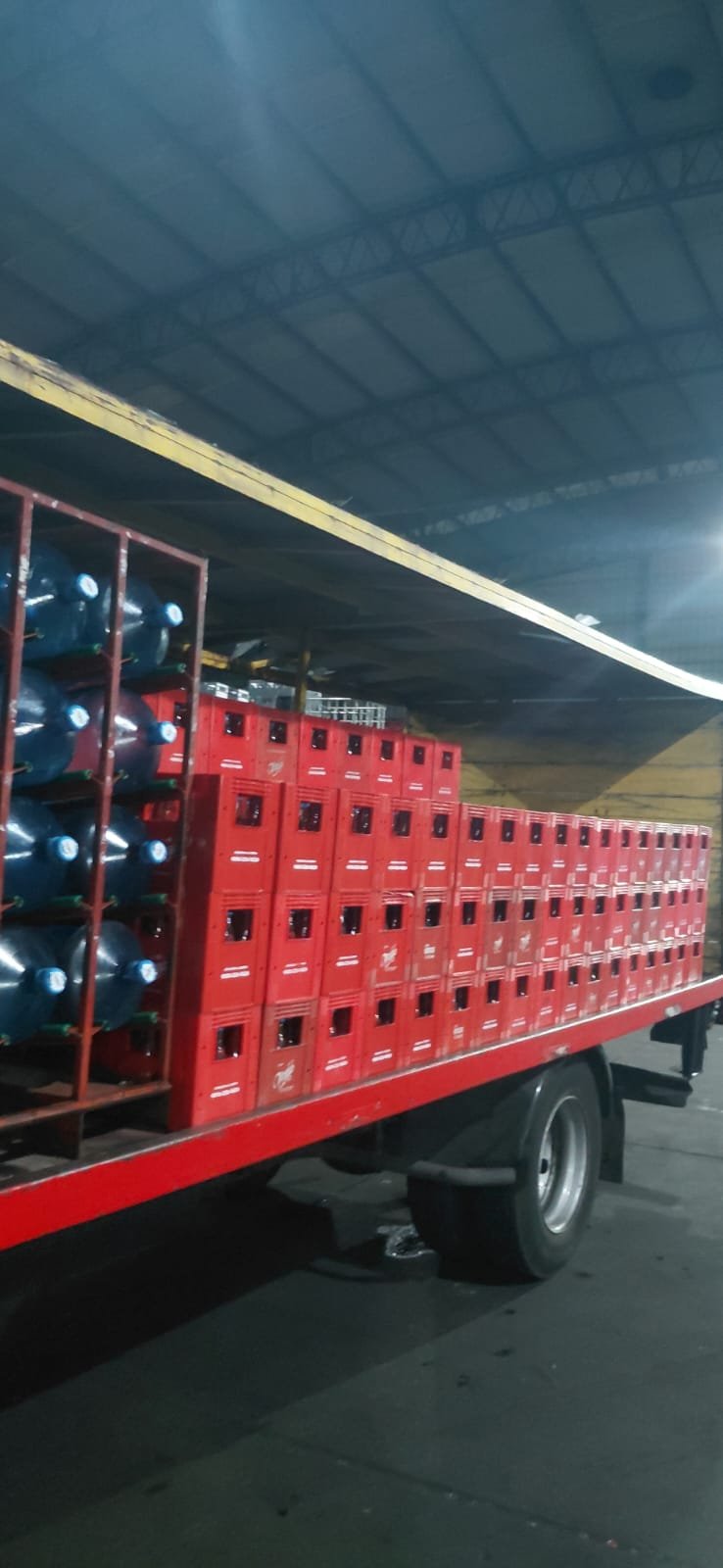 Camión con bidones de agua de 20 litros y cajones de soda en el depósito